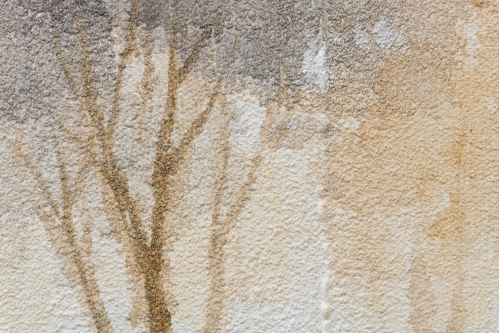 Dettaglio della pennellata sul quadro dipinto a mano con motivo paesaggio di alberi nei colori blu e marrone – primo piano sugli strati di colore.