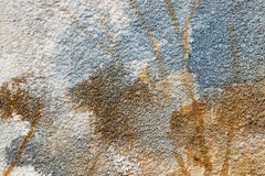 Dettaglio delle sfumature di colore sul quadro dipinto a mano con motivo paesaggio di alberi nei colori blu e marrone – delicati tratti acrilici.