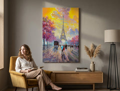 Quadro dipinto a mano con motivo torre Eiffel con cielo rosa-giallo appeso in un interno moderno ed elegante sopra una consolle in legno con vaso e candela.