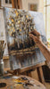 Quadro murale dipinto TREES 1 parte - 60x60 cm. Dipinto a mano originale su tela, decor autentico per interni, una donna ammira l'opera in un interno elegante luminoso. Papilora — Crafted for Home (CFAZH5236E1).