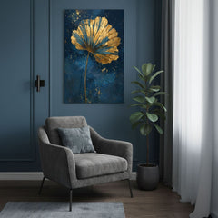 Quadro con foglia di ginkgo dorata sopra una poltrona grigia vicino a una parete blu
